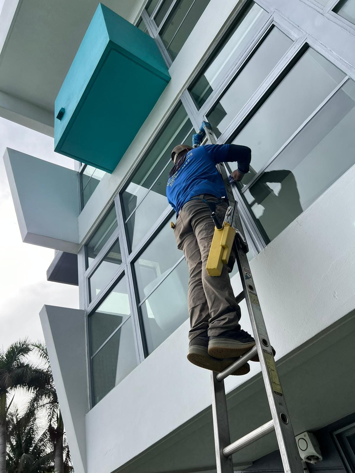 man cleaning the glass of commercial property
